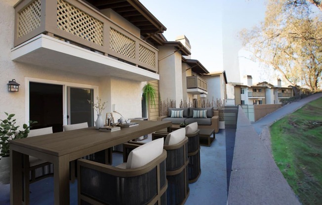 a patio with tables and chairs outside a house