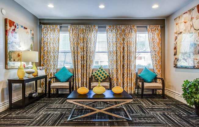 A living room with a black and white patterned carpet and a large window with curtains.