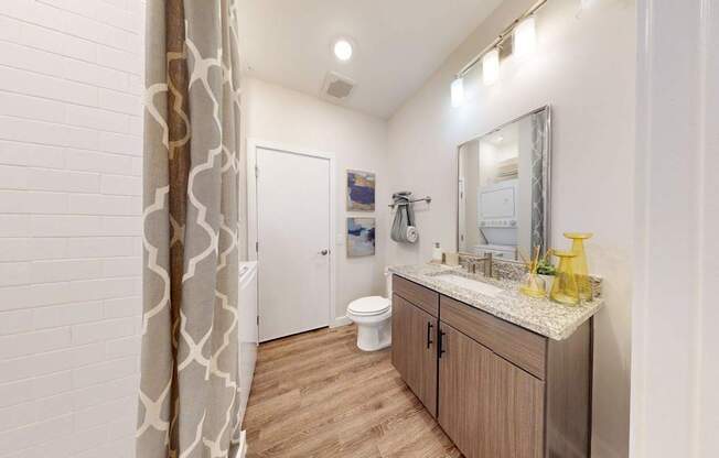A bathroom with a wooden vanity and a white toilet.