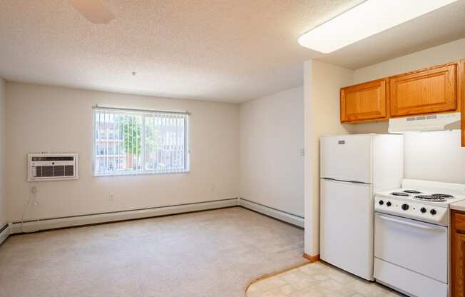 an empty kitchen with white appliances and a window.  Eagan, MN Glen Pond Apartments