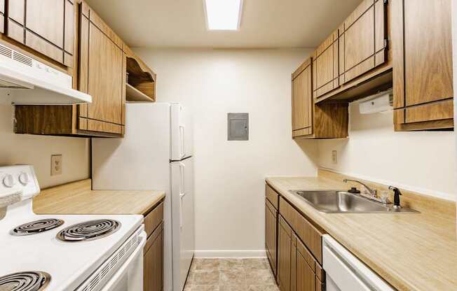 A kitchen with wooden cabinets and a white stove top oven