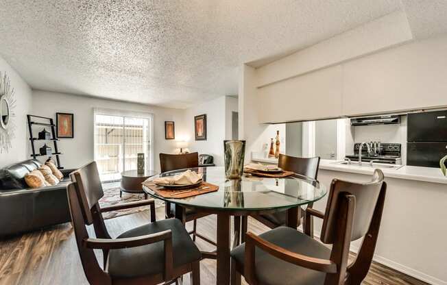 the living room and dining area of an apartment with a table and chairs