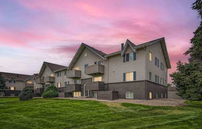 Apartments in Aurora, CO 80011 for Rent – Aurora Meadows - A large, modern apartment with a well-manicured lawn in front.