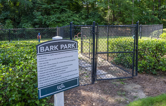 a sign for Wynnwood Vinings bark park in front of a fence