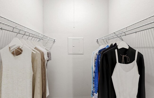 a small walk in closet with white walls and a white light switch on the wall