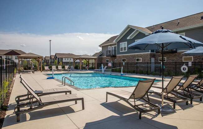 A pool surrounded by chairs and umbrellas.