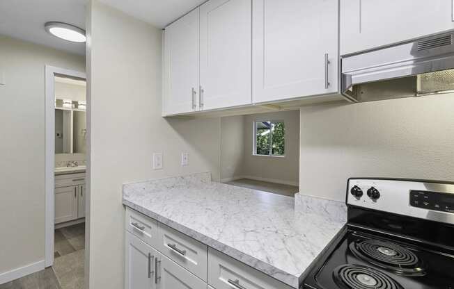 Lovely Kitchen with White Cabinets, Plank Flooring, and Efficient Appliances at Casa Blanca Apartment Homes, Everett, WA, 98204