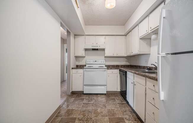 Omaha, NE Evergreen Terrace Apartments. A kitchen with white cabinets and white appliances