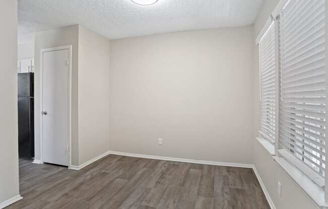 a bedroom with hardwood floors and a large window