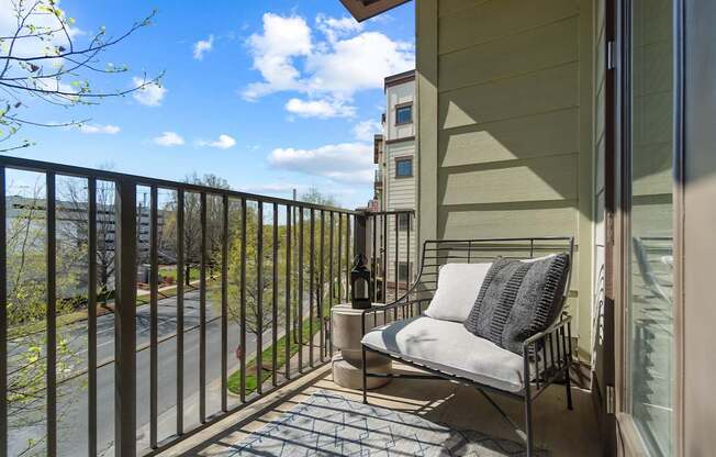 A balcony with a chair and a table.