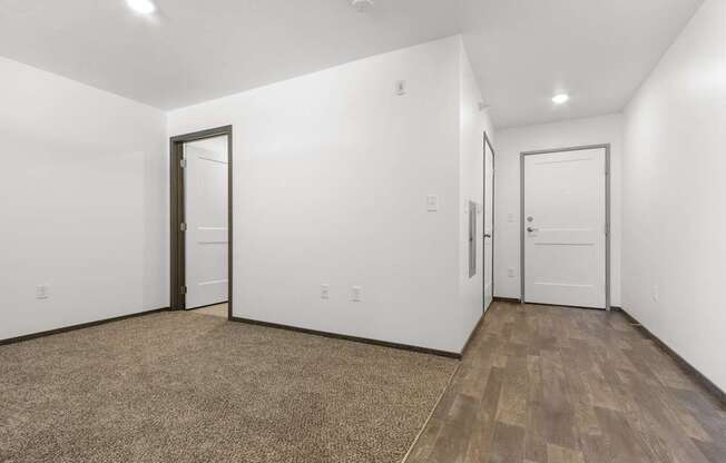A room with a brown carpet and white walls.