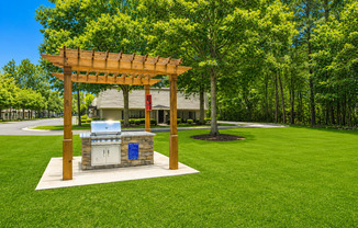 A wooden pergola with a grill on a patio.