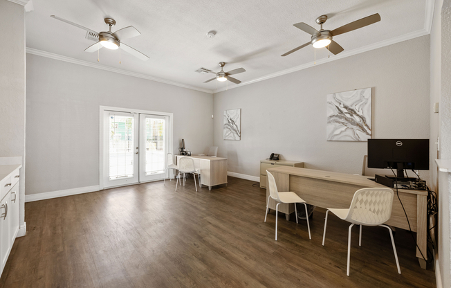 Bright and modern office space featuring sleek desks, comfortable seating, and elegant ceiling fans, perfect for productivity.
