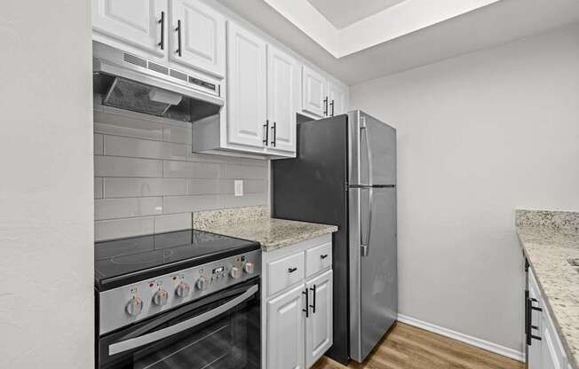 A kitchen with a black refrigerator, stove, and oven.