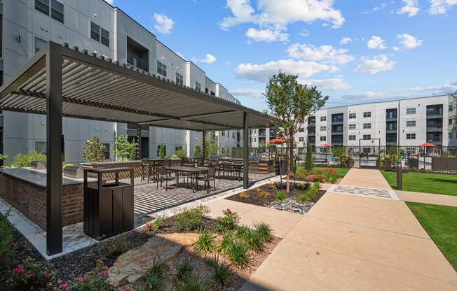 an outdoor patio with tables and chairs and a building in the background