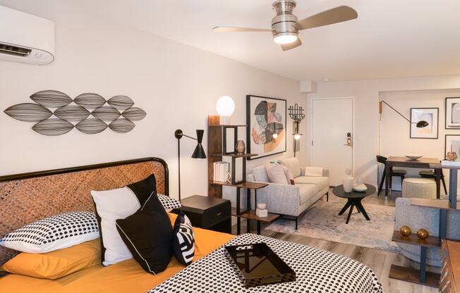 a bedroom with a bed and a living room with a couch