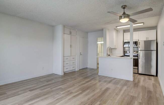 A kitchen with a refrigerator, stove, and cabinets.