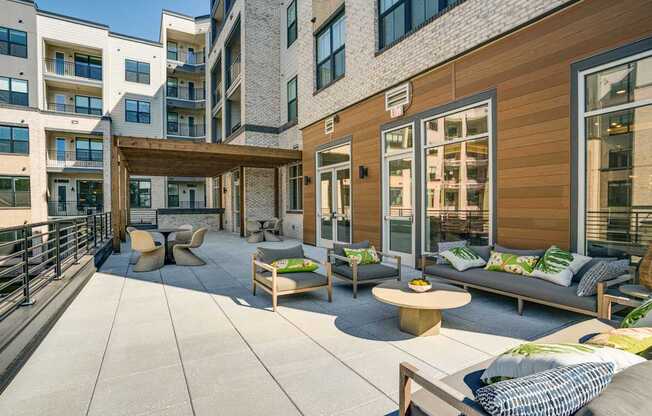 the private patio of an apartment building with furniture and a table