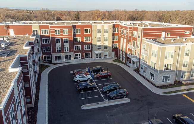 an aerial view of a parking lot in front of an apartment building
