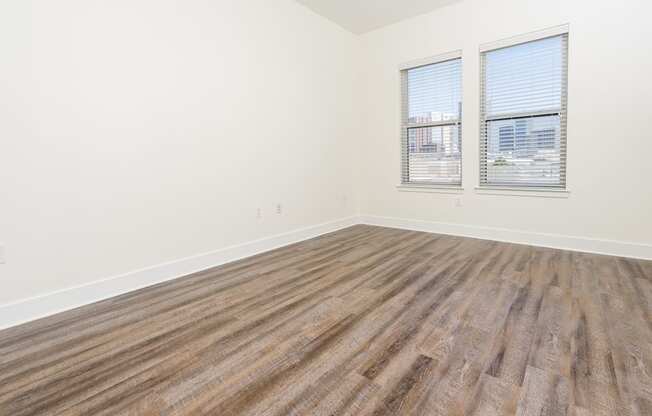 a bedroom with hardwood floors and white walls