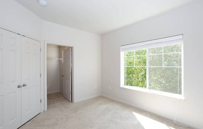 A white room with a window and a door at Wilsonville Summit Apartments, Oregon