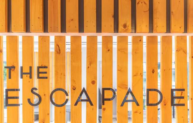 a sign for the escape room is painted on a wooden gate