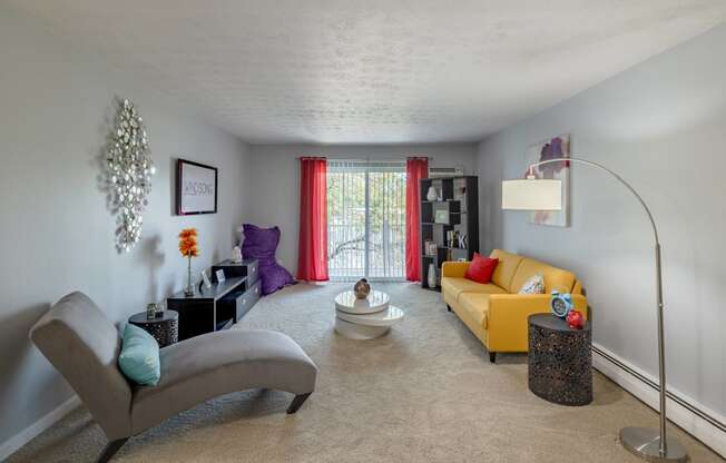 a living room with a yellow couch and a chair and a table