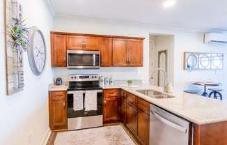 A kitchen with wooden cabinets and a stove top oven.at Carson Street Towers, Overland Park, 66223