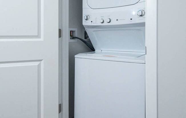 a white washer and dryer in a room with a door