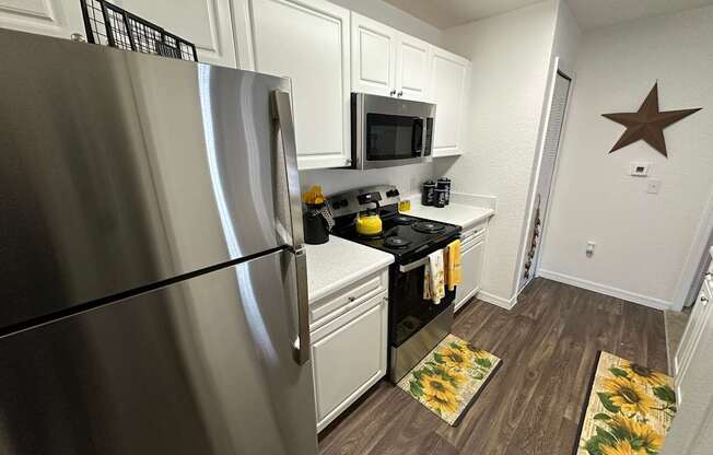 A kitchen with a stainless steel refrigerator, microwave, and a star decoration on the wall.