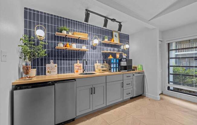 A kitchen with a blue tile backsplash and wooden countertops.