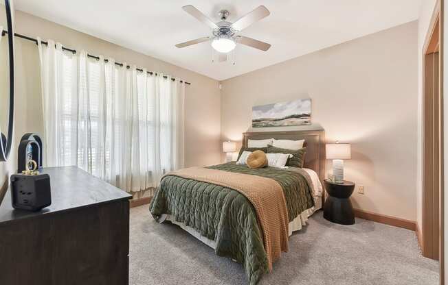 a bedroom with a large bed and a ceiling fan