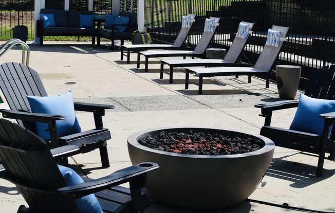 an outdoor seating area with chairs around a fire pit
