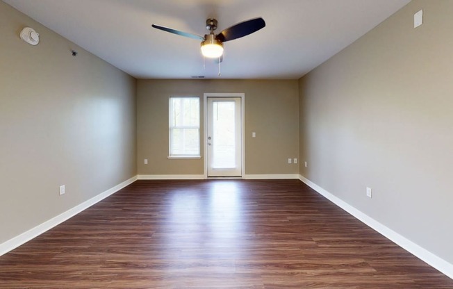 living room with hard-surface floors and a ceiling fan