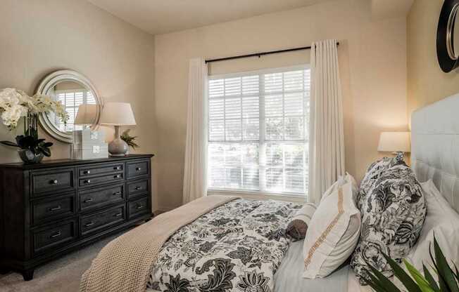 Cozy bedroom with dresser, mirror and soft window light