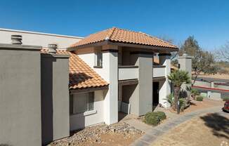 A house with a red tile roof and a white wall.