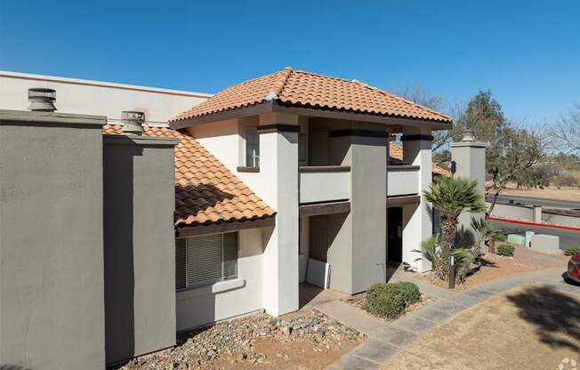 A house with a red tile roof and a white wall.