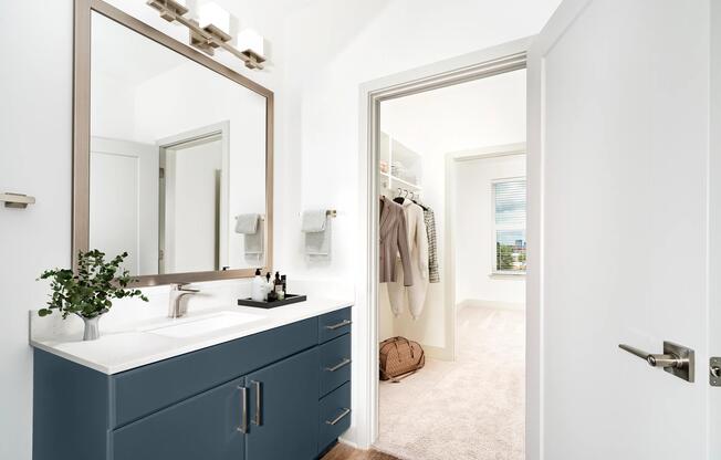 A refined bathroom at Modera Westside Trail flows seamlessly into a spacious closet, creating a thoughtfully connected daily routine.