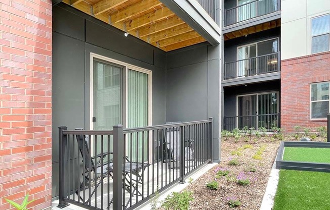 A balcony with a black railing and a glass door.