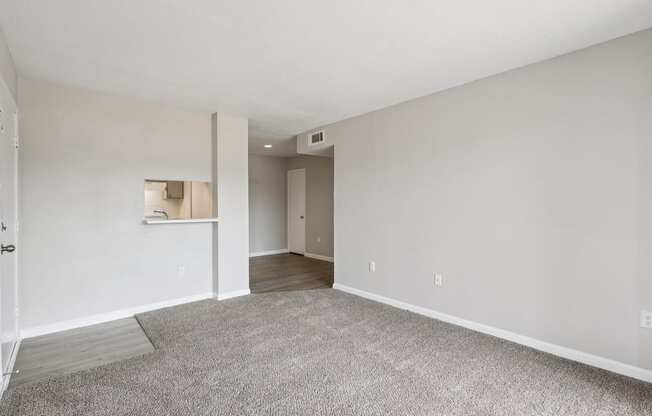 A spacious room with a carpeted floor and white walls.