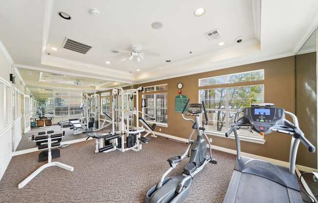 a gym with exercise machines and windows