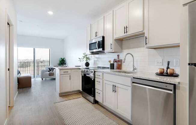 A modern kitchen with stainless steel appliances and white cabinets.