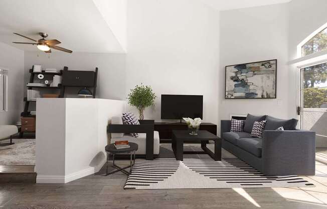 A living room with a grey couch, a black TV, and a striped rug.