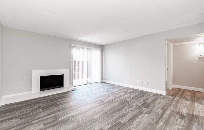 A2 upgraded living room with a fireplace and sliding door leading to balcony at Vine Apartments in Arlington, TX