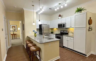 A kitchen with a bar area and stools.