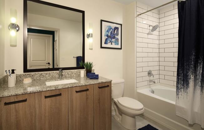 Bathroom with mirror and wooden cupboard at Azola West Palm Beach, Florida