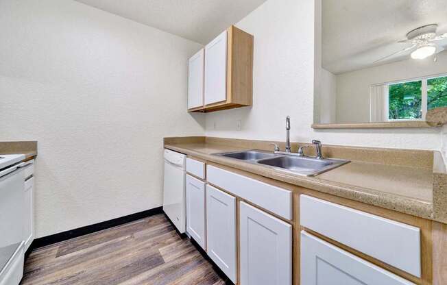 A kitchen with white cabinets and a wooden counter top.