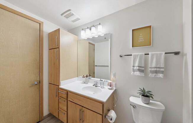 A bathroom with a white sink and a toilet.
