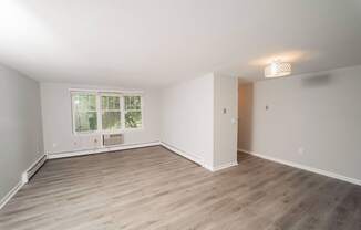 a living room with wood floors and white walls and a window  at Enclave West Hartford / Parc West, West Hartford