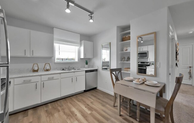 Enjoy modern living at Esperanza at Wild Orchid. This stylish kitchen features sleek white cabinetry, top-notch appliances, and an inviting dining space, perfect for gatherings. Schedule your visit today and make this your new home!